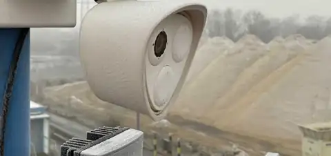 Vereiste Außenkamera auf einer Metallhalterung auf einem Industriegelände.