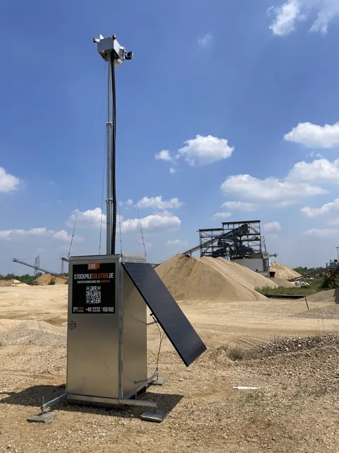 Mobiler Kameramast mit Technikgehäuse und Solarmodul vor Schüttguthalden.